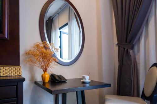 a room with a table with a mirror on the wall at Hanoi Center Silk Charming Hotel & Travel in Hanoi