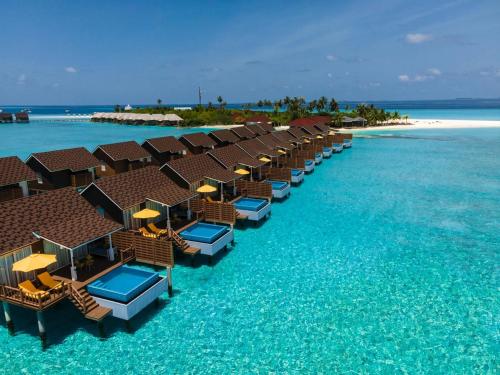 an aerial view of a beach with chairs and the ocean at Dhigufaru Island Resort in Baa Atoll