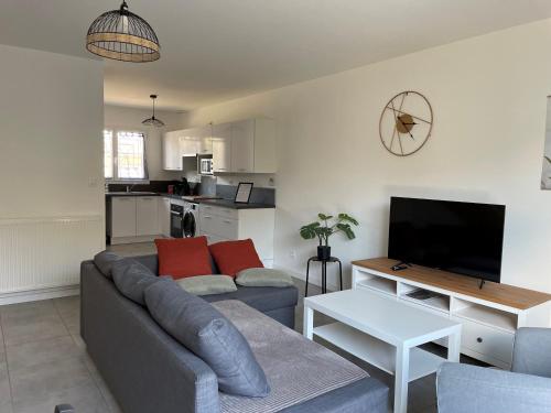 un salon avec un canapé et une télévision dans l'établissement Les Villas de Castel - Villa Les Roses, à Castelmaurou