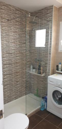 a shower in a bathroom with a washing machine at Casa Millie in Playa Flamenca