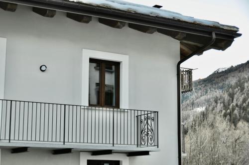a white building with a balcony and a window at Case Verdi in Bardonecchia