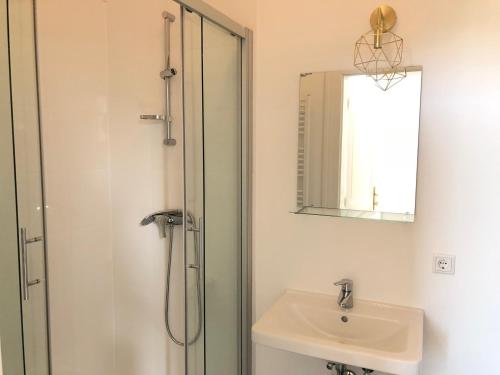 uma casa de banho com um chuveiro, um lavatório e um espelho. em Classic, Modern&Charming! 7min to Vienna’s center! em Viena