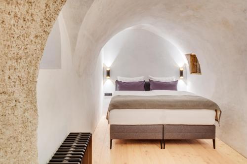 a bedroom with a bed in a white room at Boutiquehotel Rattenberg in Rattenberg
