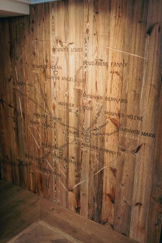 a wall with writing on a wooden wall at Hôtel Chalet Mounier in Les Deux Alpes