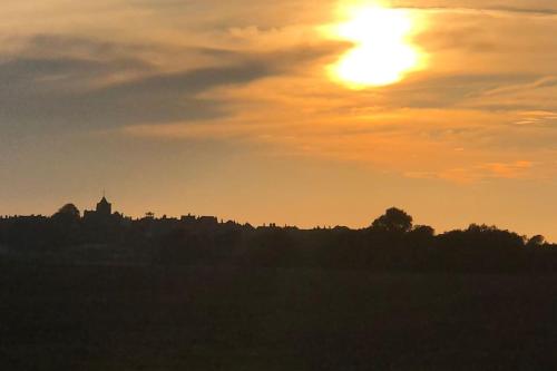 a sunset over a field with the sun in the sky at The Old Laundry in Rye
