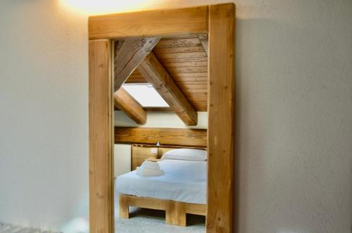 a mirror in a room with a bed at Case Verdi in Bardonecchia