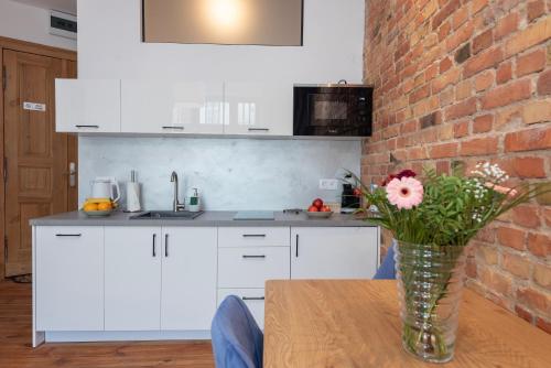 a kitchen with a vase of flowers on a table at PROVENIR HOME KWIATOWA 5 in Poznań