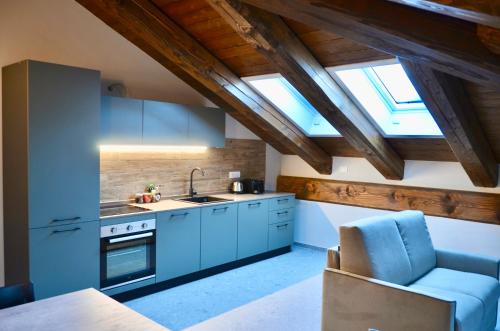uma cozinha no sótão com armários azuis e uma cadeira azul em Case Verdi em Bardonecchia