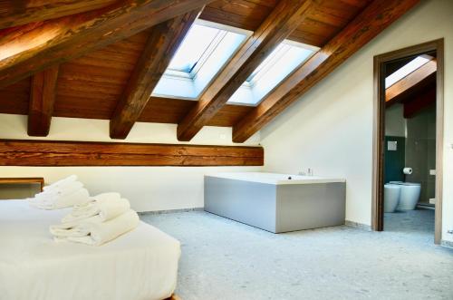 a attic bathroom with a bed and a bath tub at Case Verdi in Bardonecchia