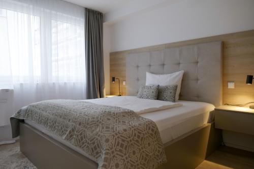 a bedroom with a large bed with a large window at Aparthotel Cosy in Stuttgart