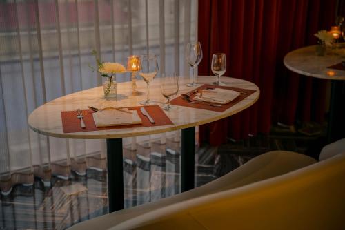 a table with wine glasses and napkins on it at Le Jardin Hotel Haute Couture in Hanoi