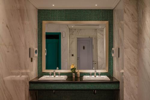 a bathroom with two sinks and a large mirror at Le Jardin Hotel Haute Couture in Hanoi
