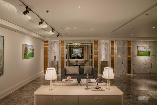 a living room with two lamps and a couch at Le Jardin Hotel Haute Couture in Hanoi