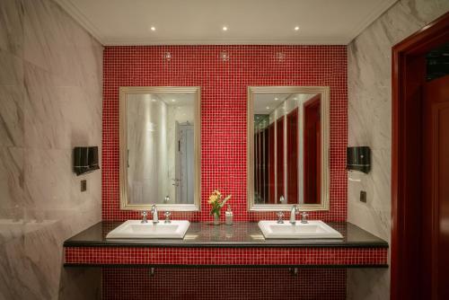 a bathroom with two sinks and red tile at Le Jardin Hotel Haute Couture in Hanoi