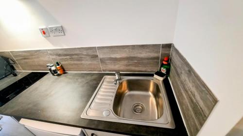 a stainless steel sink in a small kitchen at Burford Road - Stay. Sleep. Rest. in Nottingham