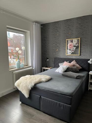 een slaapkamer met een groot bed en een raam bij Quartier Lookvenne Wohnung 1 in Emden