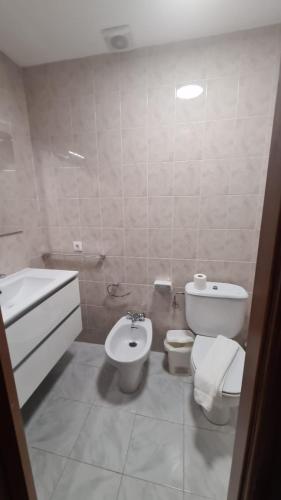 a white bathroom with a toilet and a bidet at Villas Estrellas 11 in Ciutadella