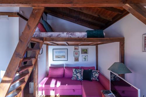 アルベルガリア・ア・ヴェーリャにあるVale da Silva Villas - Homesの二段ベッド付きの客室で、ピンクのソファが備わります。