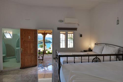 1 dormitorio con cama y vistas al océano en John's Guesthouse, en Ksamil