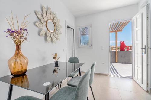 a dining room with a glass table and chairs at Sonia in Mýkonos City