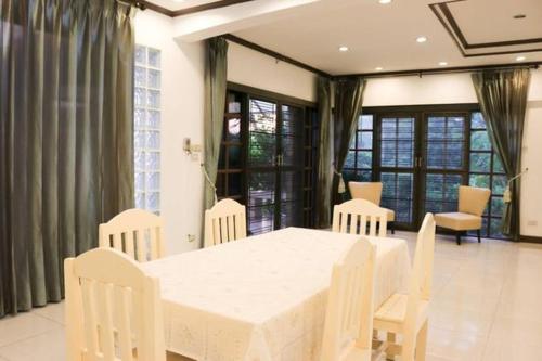 uma sala de jantar com uma mesa branca e cadeiras em Bed By Cruise Hotel At Samakkhi-Tivanont em Nonthaburi