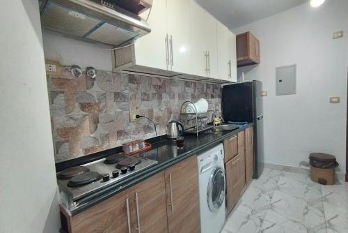 uma cozinha com um lavatório e um fogão forno superior em شاليه للايجار اليومى بورتو سعيد em Port Said