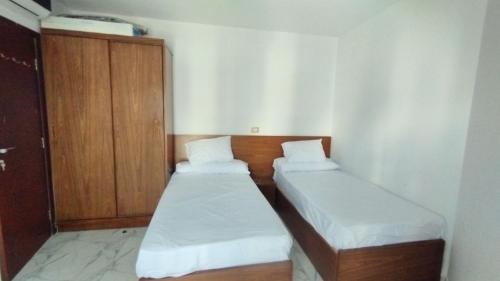 Cette petite chambre comprend 2 lits et une armoire. dans l'établissement شاليه للايجار اليومى بورتو سعيد, à Port-Saïd