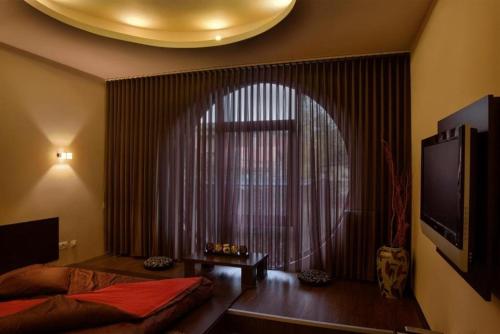 a bedroom with a bed and a large window at HOTEL DECENTRIA in Timişoara
