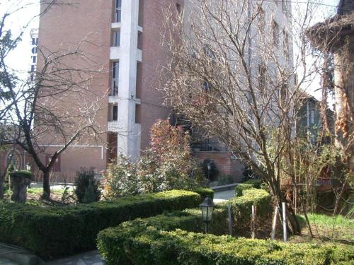 a brick building with bushes in front of a building at HOTEL DECENTRIA in Timişoara