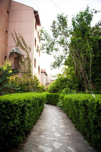 a path through a hedge next to a building at HOTEL DECENTRIA in Timişoara