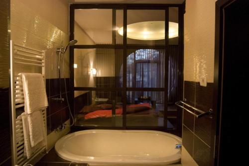 a bathroom with a bath tub in a room at HOTEL DECENTRIA in Timişoara