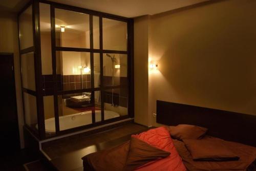 a bedroom with a bed and a large window at HOTEL DECENTRIA in Timişoara