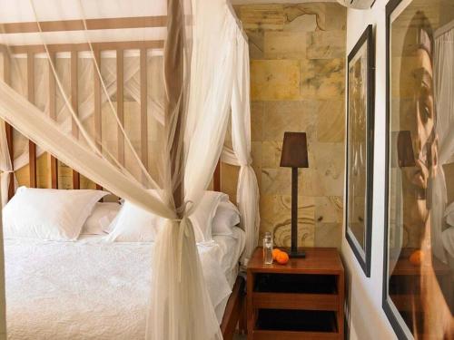 a bedroom with a canopy bed with white curtains at Kasbah 1 in Cala Vadella