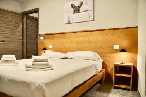 a bedroom with a large bed with white sheets and pillows at Case Verdi in Bardonecchia
