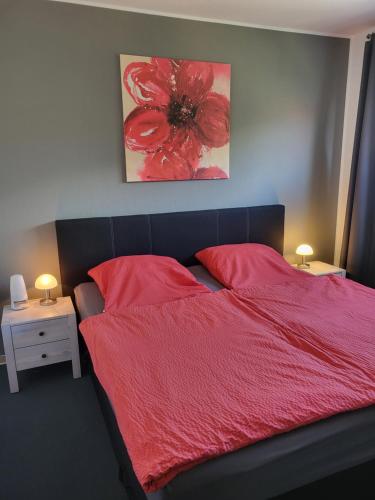 a bedroom with a red bed with two red pillows at Moderne Ferienwohnung im Herzen von Schleswig in Schleswig