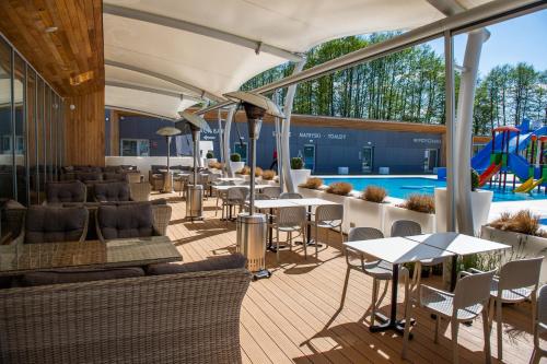 een restaurant met tafels en stoelen en een zwembad bij Hotel Kozerki in Kozerki