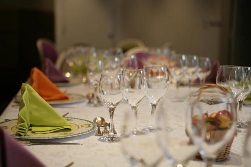 a table with wine glasses and plates on it at Logis Hôtel Restaurant Le Fruitier in Villedieu-les-Poëles
