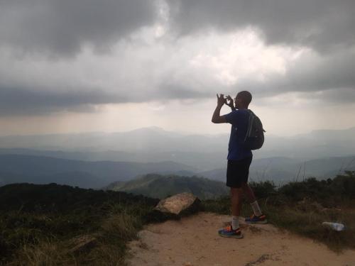a man standing on top of a mountain taking a picture at The Inn At Matale in Matale