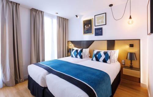 a hotel room with a large bed with a blue blanket at Star Champs-Elysées in Paris