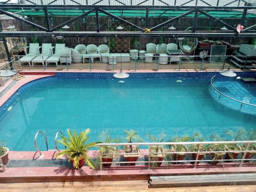 a large swimming pool with chairs and a swimming pool at Hotel 5 Flowers Ananta Elite in Kota