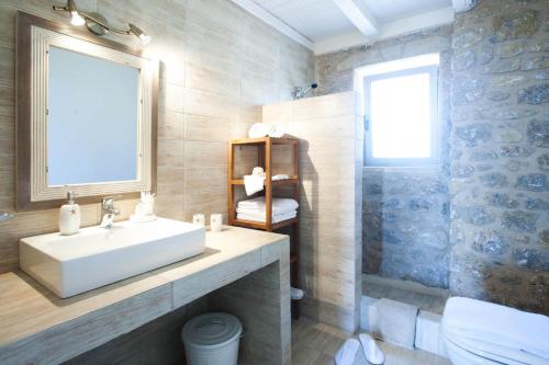 La salle de bains est pourvue d'un lavabo blanc et d'une fenêtre. dans l'établissement Poliana Estate Villas, à Riglia