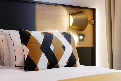 a bedroom with a bed with pillows and a headboard at Star Champs-Elysées in Paris