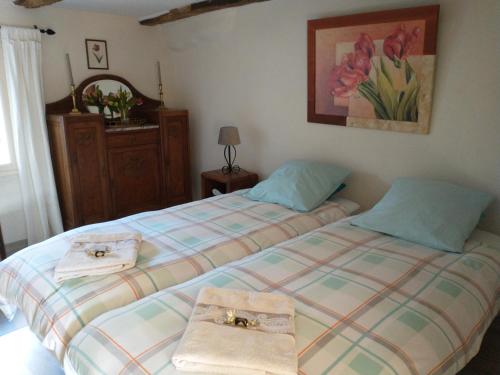 a bedroom with two beds with towels on them at Domaine de Cadenne in Saint-Antonin