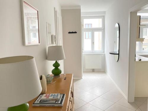 een witte woonkamer met een tafel en een lamp bij Modern & Charming @ Villas quarter! 7min to Center in Wenen