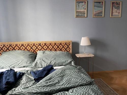 an unmade bed in a bedroom with a lamp on a table at Modern & Charming @ Villas quarter! 7min to Center in Vienna
