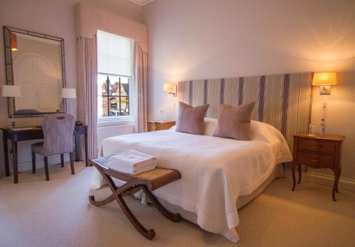 a bedroom with a bed and a desk and a window at The Jockey Club Rooms in Newmarket