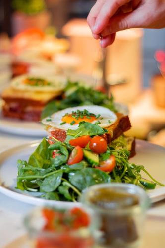a plate of food with a salad on a table at Ilonn Boutique Limanowskiego in Poznań