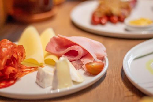 a plate of food with cheese and meats on a table at Ilonn Boutique Limanowskiego in Poznań
