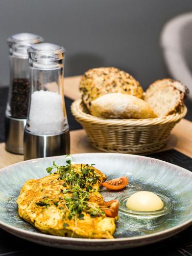 a plate of food with eggs and bread on a table at Ilonn Boutique Limanowskiego in Poznań