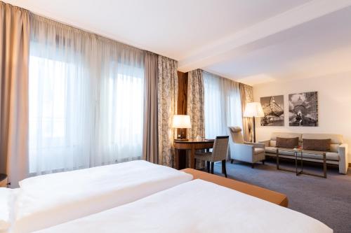 um quarto de hotel com duas camas e um sofá em Hotel Europäischer Hof Hamburg em Hamburgo